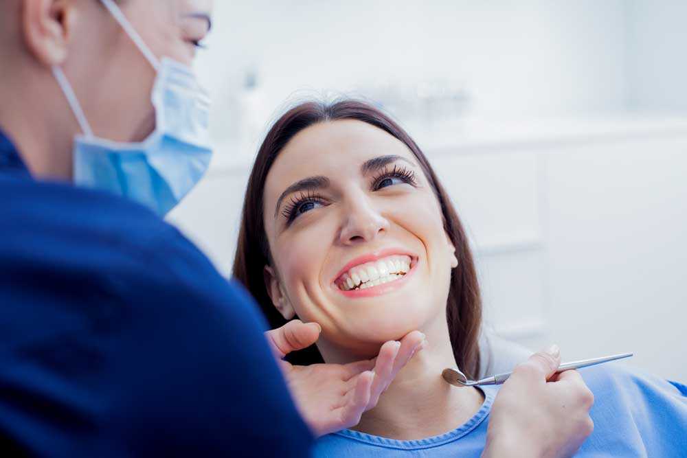 Leende kvinna i tandläkarstol