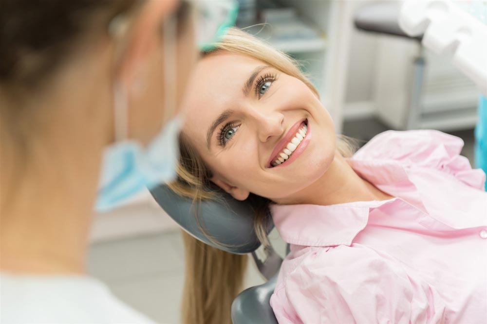 Kvinna i tandläkarstol som ler